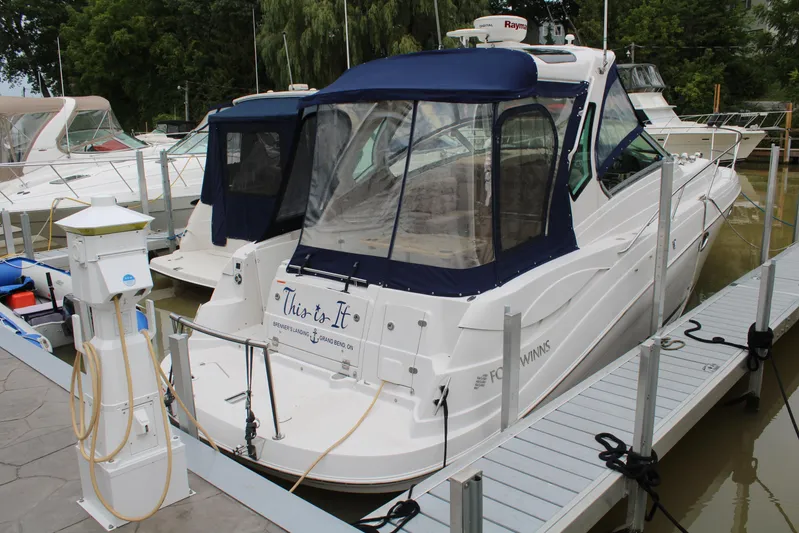  Yacht Photos Pics 2011 Four Winns V335 boat docked with blue canopy and clear windows.