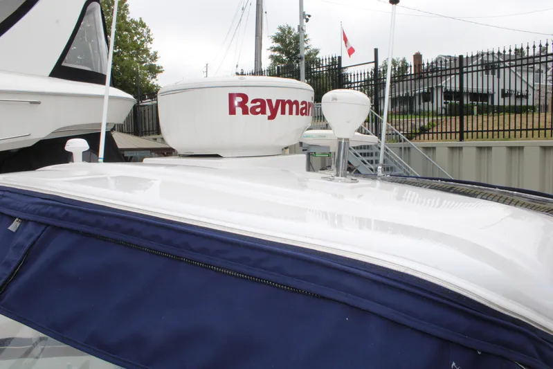  Yacht Photos Pics 2011 Four Winns V335 boat with Raymarine radar, docked near a fence.
