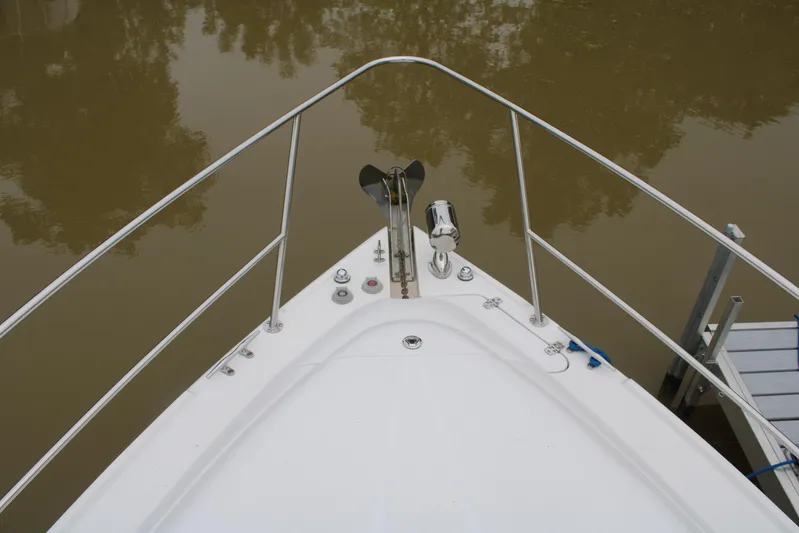  Yacht Photos Pics Bow view of 2011 Four Winns V335 boat, anchored on calm water.