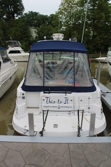  Yacht Photos Pics 2011 Four Winns V335 boat docked, rear view with blue canopy and "This is It" sign.