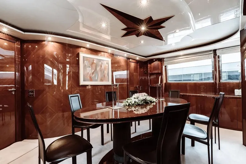 Let It Be Yacht Photos Pics Luxurious dining area on 1998 Tecnomarine Custom yacht with elegant wood paneling and modern decor.