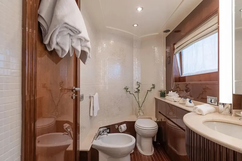 Let It Be Yacht Photos Pics Luxurious Tecnomarine Custom 1998 yacht bathroom with elegant wood accents and modern fixtures.