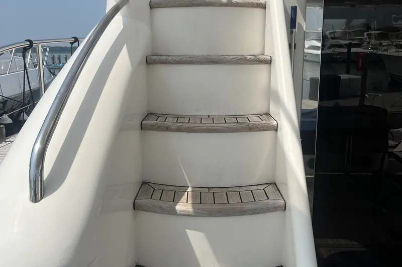 C Glass Yacht Photos Pics Staircase on a 2000 Princess 65 M/Y yacht with wooden steps and metal railing.