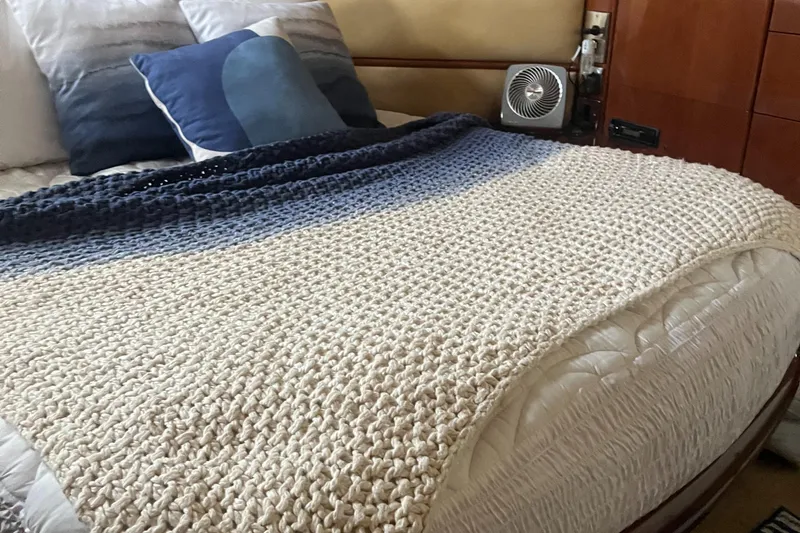 C Glass Yacht Photos Pics Cozy bed with knitted blanket and pillows on a Princess 65 M/Y yacht, 2000 model.