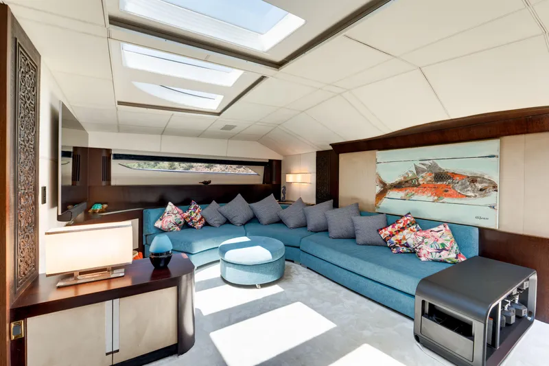 Ginger Yacht Photos Pics Luxurious interior of 2006 Pershing 115 yacht with skylights, blue sofa, and vibrant artwork.
