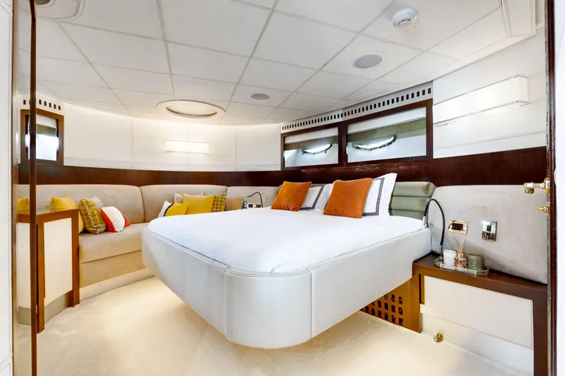 Ginger Yacht Photos Pics Luxurious bedroom interior on a 2006 Pershing 115 yacht, featuring modern design and cozy seating.