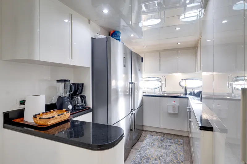 Ginger Yacht Photos Pics Modern kitchen interior on a 2006 Pershing 115 yacht, featuring sleek white cabinetry and stainless steel appliances.