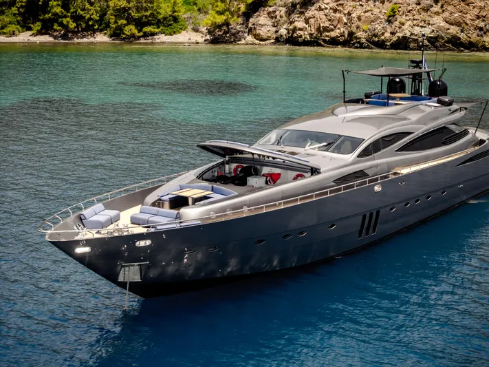 Ginger Yacht Photos Pics Luxurious 2006 Pershing 115 yacht on serene blue waters near rocky shoreline.