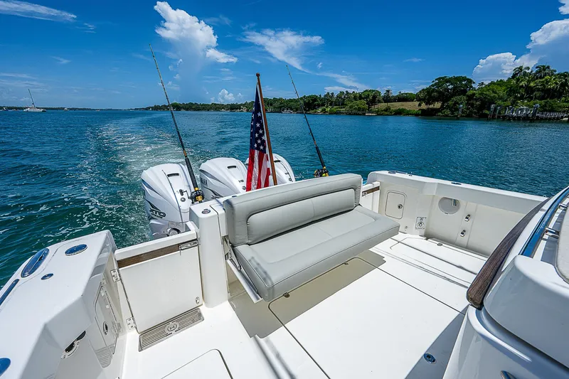 Tropical Breeze Yacht Photos Pics 2020 Hinckley Sport Boat 40 C on water, featuring spacious deck and American flag.