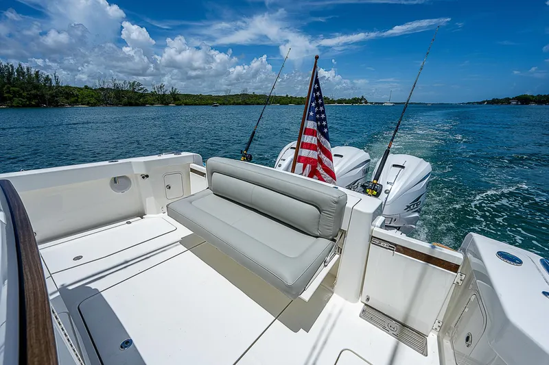 Tropical Breeze Yacht Photos Pics 2020 Hinckley Sport Boat 40 C, rear view with American flag, on open water.