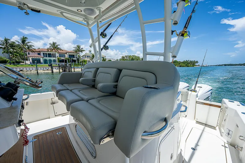 Tropical Breeze Yacht Photos Pics 2020 Hinckley Sport Boat 40 C with luxurious seating, docked by waterfront homes.