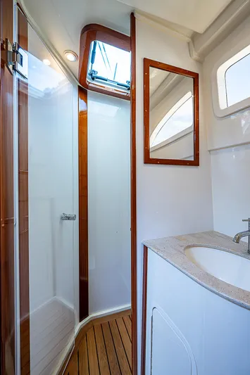 Tropical Breeze Yacht Photos Pics 2020 Hinckley Sport Boat 40 C bathroom with shower, wooden accents, and modern fixtures.