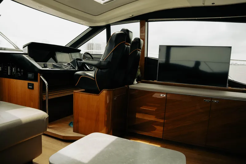 Amaray Yacht Photos Pics Interior of 2020 Princess S62 yacht with helm, leather seating, and wooden cabinetry.