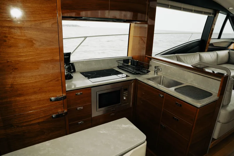 Amaray Yacht Photos Pics Luxurious kitchen interior of 2020 Princess S62 yacht with modern appliances and wood finish.