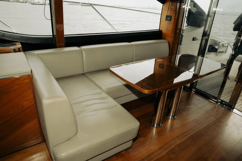 Amaray Yacht Photos Pics Luxurious interior of 2020 Princess S62 yacht with leather seating and wooden table.