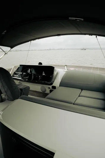 Amaray Yacht Photos Pics Luxurious 2020 Princess S62 yacht interior with sleek seating and modern helm, overlooking calm waters.