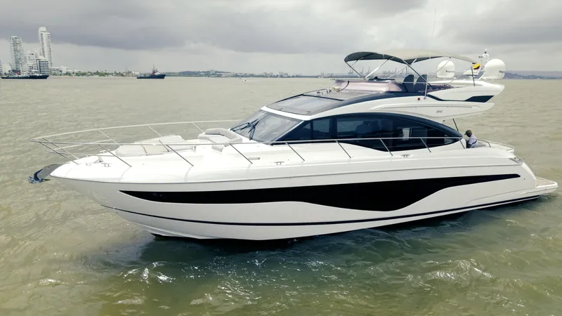 Amaray Yacht Photos Pics Luxurious 2020 Princess S62 yacht cruising on calm waters under cloudy skies.