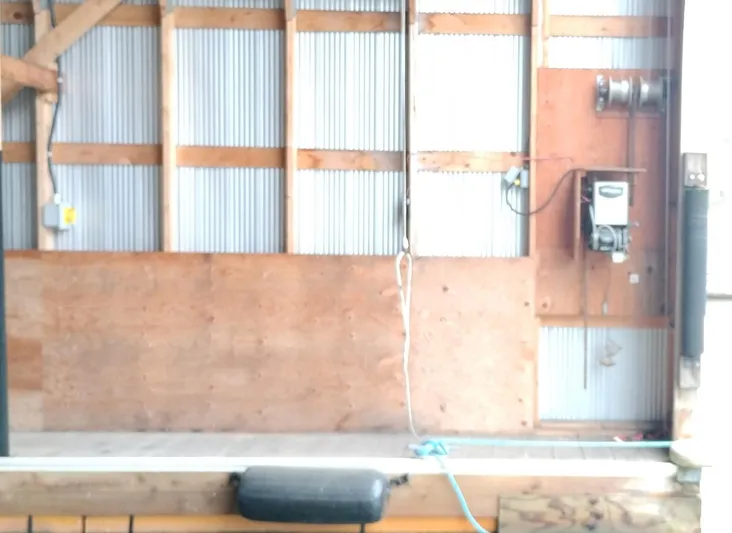  Yacht Photos Pics Custom 2012 boathouse interior with wooden and metal paneling, electrical equipment, and dock bumper.