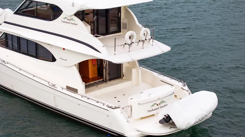 Unchained Freedom Yacht Photos Pics 2007 Maritimo M60 Cruising Motor Yacht on water, rear view with covered dinghy.