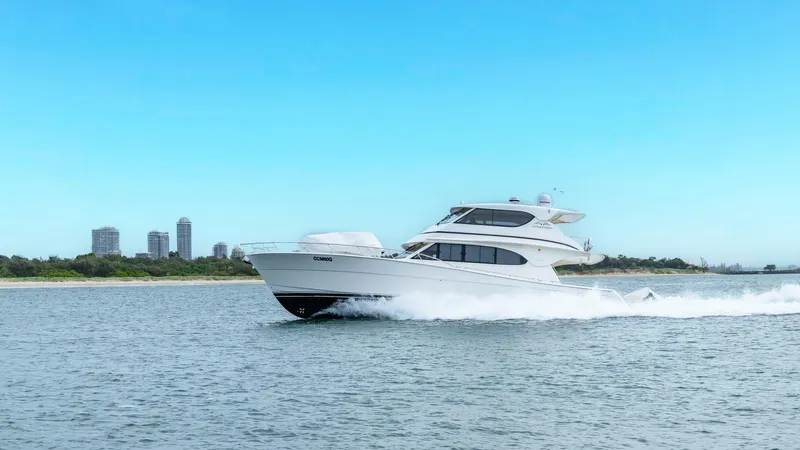 Unchained Freedom Yacht Photos Pics 2007 Maritimo M60 Cruising Motor Yacht on open water, with city skyline in background.
