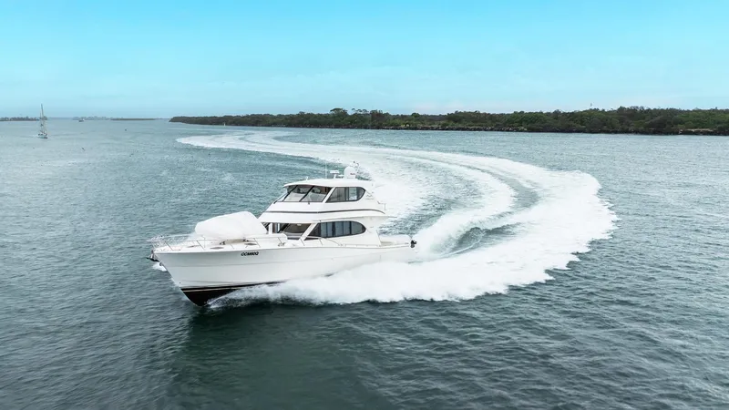 Unchained Freedom Yacht Photos Pics 2007 Maritimo M60 Cruising Motor Yacht navigating open waters with a scenic backdrop.