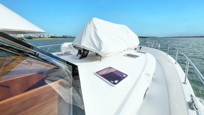 Unchained Freedom Yacht Photos Pics 2007 Maritimo M60 Cruising Motor Yacht deck with covered equipment, sailing on calm waters.