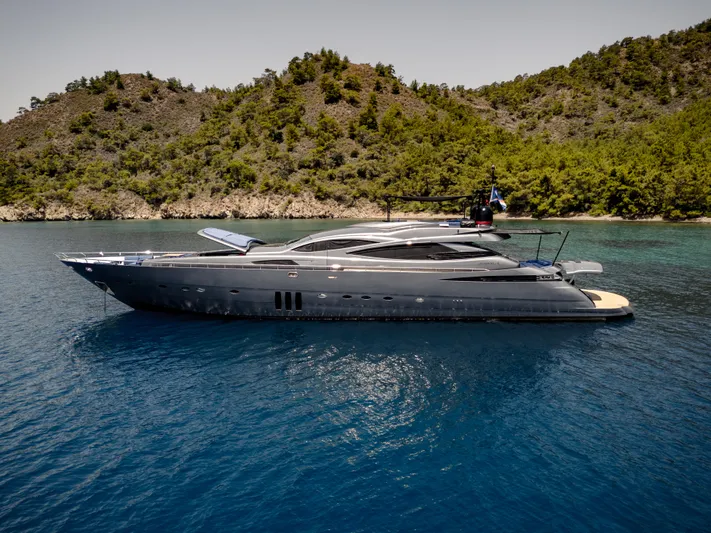 Ginger Yacht Photos Pics Luxury 2006 Pershing 115 yacht on serene blue waters near lush green coastline.