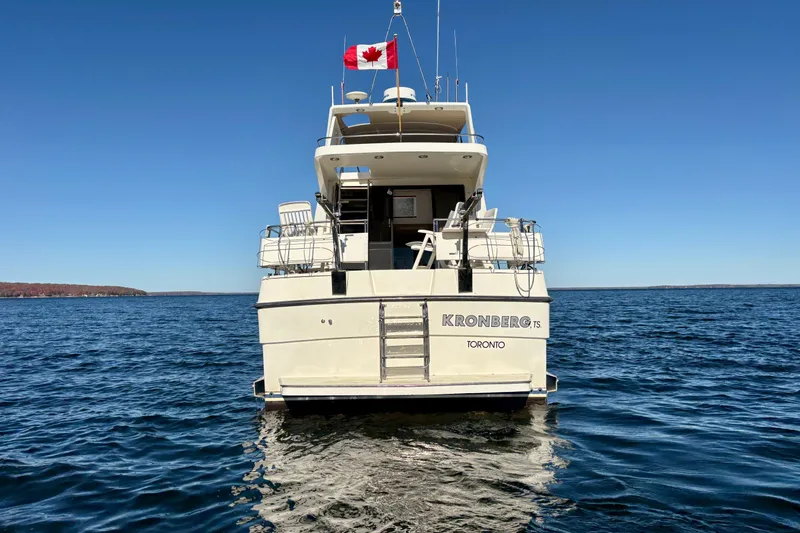 Kronberg Yacht Photos Pics 1990 Neptunus 145 AC yacht on water, Canadian flag, clear blue sky.