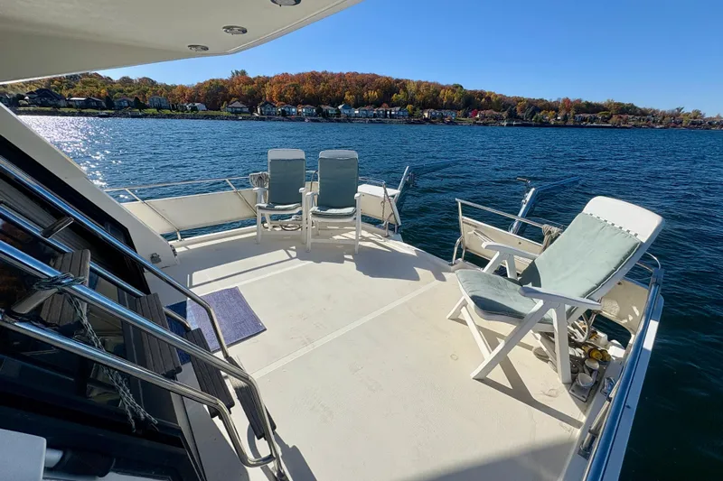 Kronberg Yacht Photos Pics Deck of 1990 Neptunus 145 AC yacht with chairs, overlooking serene lake and autumn trees.