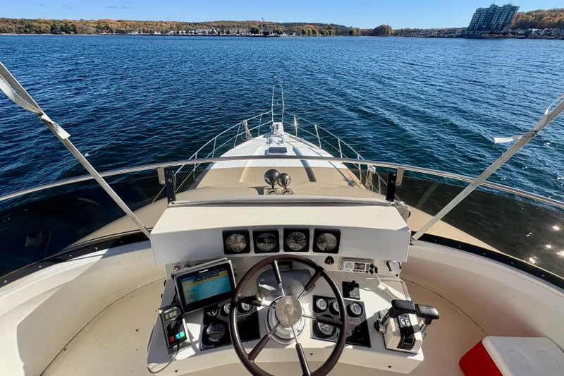 Kronberg Yacht Photos Pics Cockpit view of 1990 Neptunus 145 AC yacht on a serene lake.