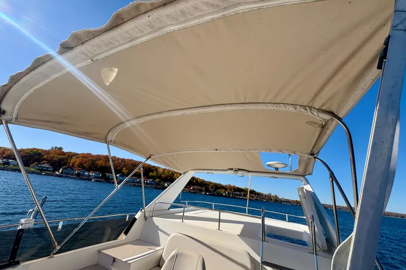 Kronberg Yacht Photos Pics 1990 Neptunus 145 AC boat with canopy on a sunny lake day.