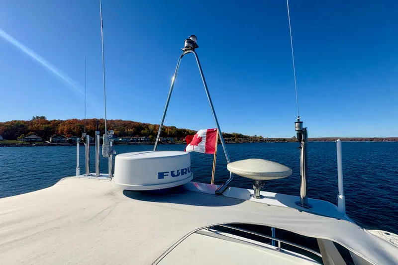 Kronberg Yacht Photos Pics 1990 Neptunus 145 AC yacht with radar, Canadian flag, on a clear lake.
