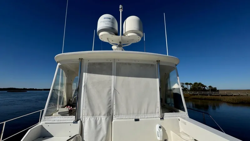 Bee Haven Yacht Photos Pics 2006 Fleming 65 Pilothouse Motor Yacht on calm water under clear blue sky.
