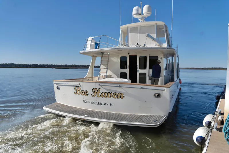Bee Haven Yacht Photos Pics Fleming 65 Pilothouse Motor Yacht 2006 cruising on calm waters, rear view.