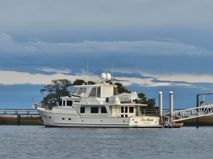 Bee Haven Yacht Photos Pics 2006 Fleming 65 Pilothouse Motor Yacht docked by a serene waterfront.