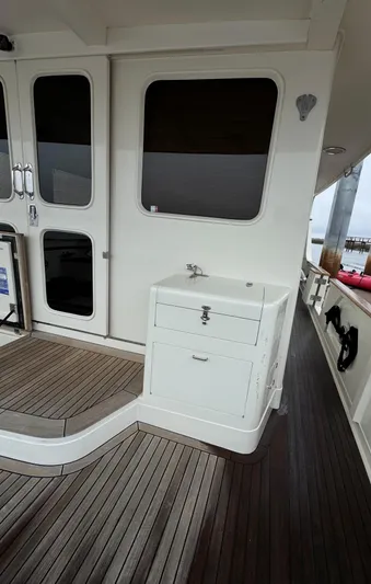 Bee Haven Yacht Photos Pics 2006 Fleming 65 Pilothouse Motor Yacht deck with wooden flooring and storage unit.