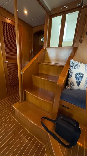 Bee Haven Yacht Photos Pics Interior of 2006 Fleming 65 Pilothouse Motor Yacht with wooden stairs and seating area.