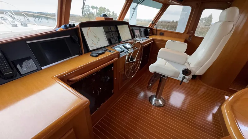 Bee Haven Yacht Photos Pics Luxurious 2006 Fleming 65 Pilothouse Motor Yacht helm with wood finish and navigation equipment.