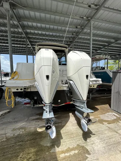  Yacht Photos Pics 2022 Boston Whaler 325 Conquest with dual outboard engines in a covered dock.