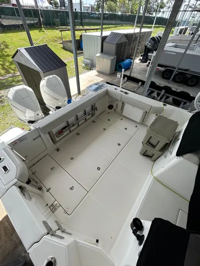  Yacht Photos Pics 2022 Boston Whaler 325 Conquest boat deck with dual engines in a marina setting.