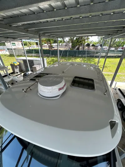 Yacht Photos Pics 2022 Boston Whaler 325 Conquest boat under shelter, featuring Raymarine radar.