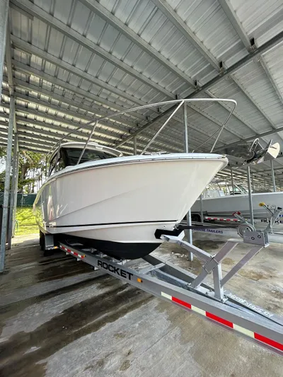  Yacht Photos Pics 2022 Boston Whaler 325 Conquest on trailer under covered storage.