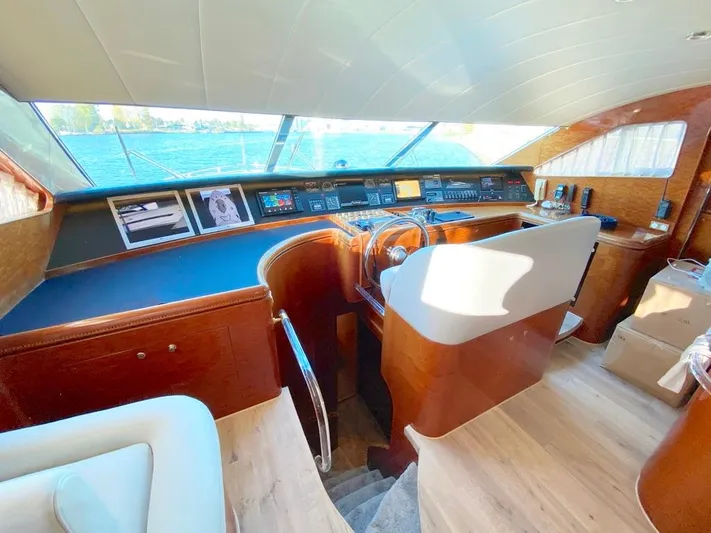 Curiosity Yacht Photos Pics Luxurious yacht interior with wooden helm, modern controls, and panoramic windows. Elegance 82 S, 2001 model.