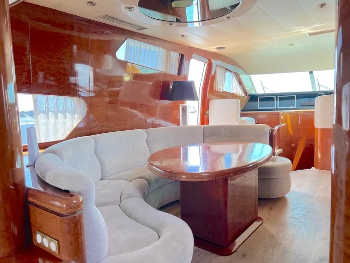 Curiosity Yacht Photos Pics Luxurious interior of 2001 Elegance 82 S yacht with plush seating and wooden finishes.