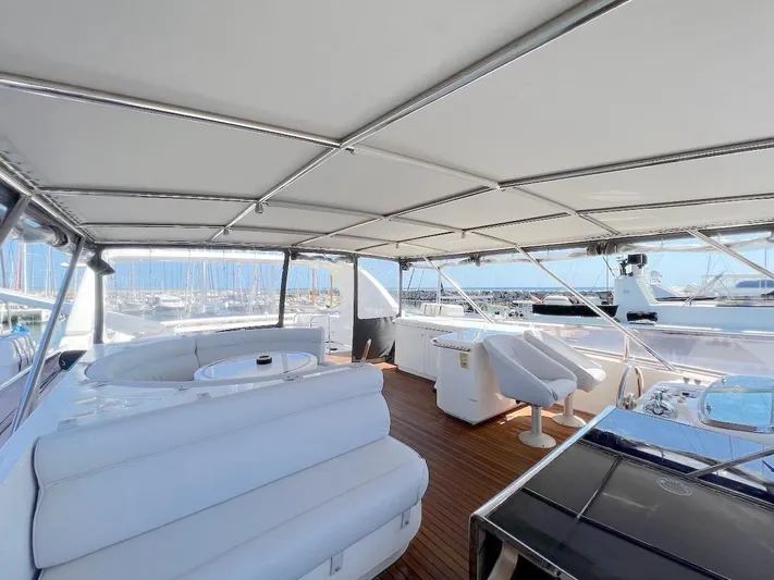 Curiosity Yacht Photos Pics Luxurious 2001 Elegance 82 S yacht interior with white seating and wooden flooring.