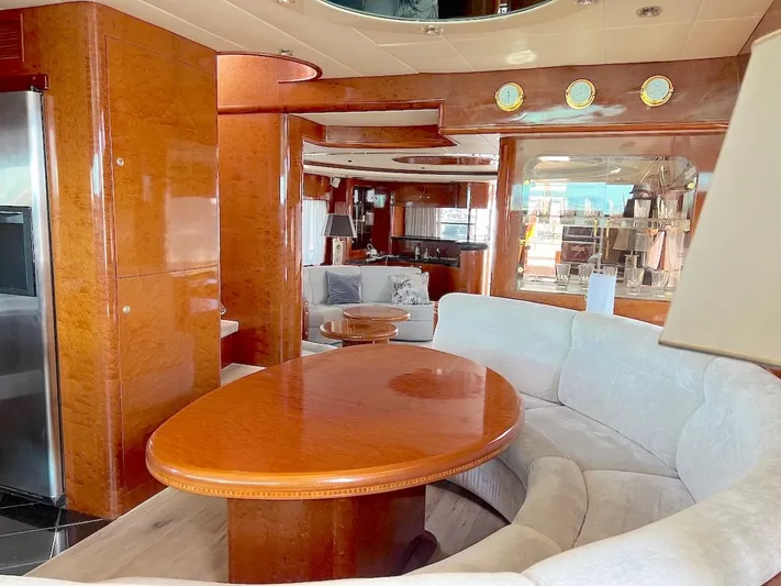 Curiosity Yacht Photos Pics Luxurious yacht interior with wooden finishes, curved seating, and elegant dining area, Elegance 82 S, 2001.
