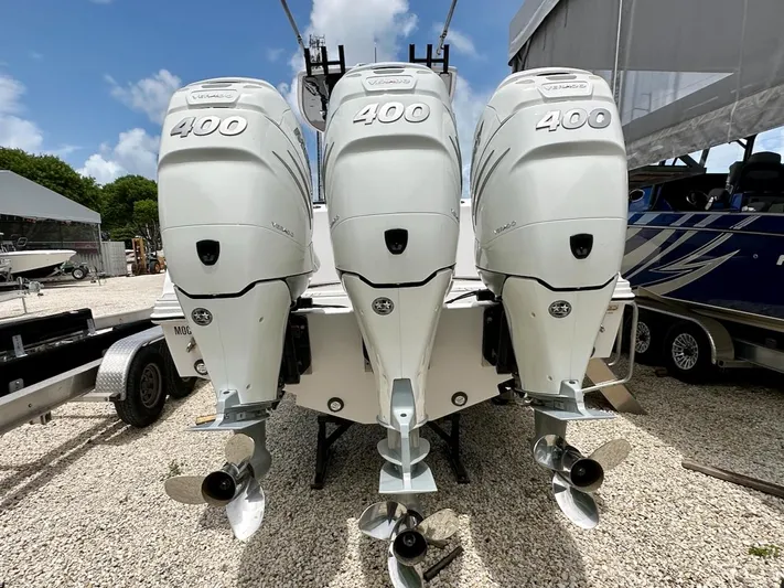  Yacht Photos Pics Triple 400 horsepower outboard engines on a 2021 Streamline 35CC boat, parked on gravel.