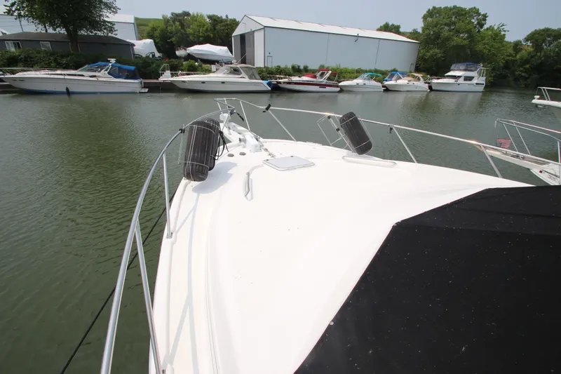  Yacht Photos Pics 1996 Bayliner 3988 Command Bridge Motoryacht docked in a marina with other boats.