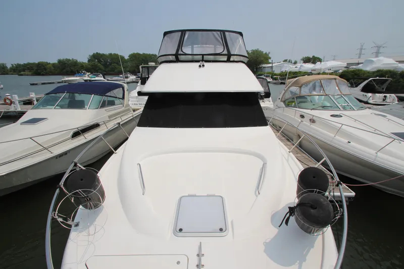  Yacht Photos Pics 1996 Bayliner 3988 Command Bridge Motoryacht docked among other boats.