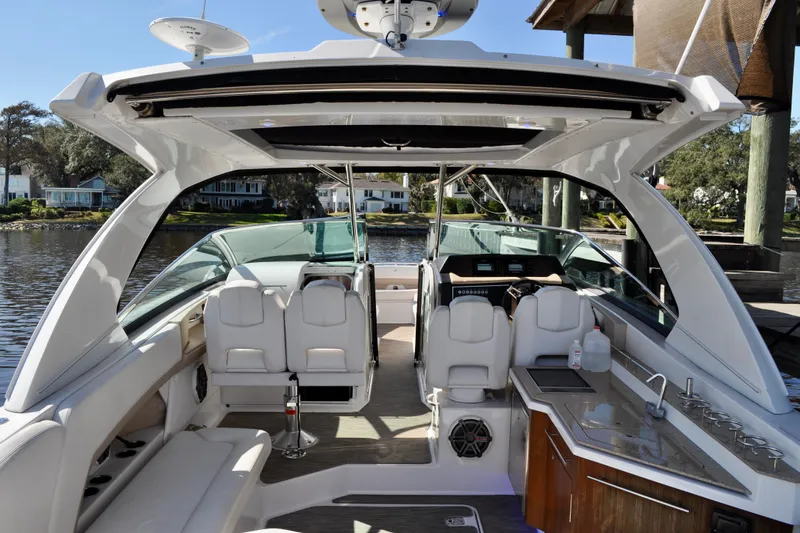  Yacht Photos Pics 2019 Four Winns H350 OB boat interior with seating, helm, and kitchenette by the water.